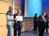 Strahlender Absolvent bei der Übergabe des Diploms durch Herrn Schihin